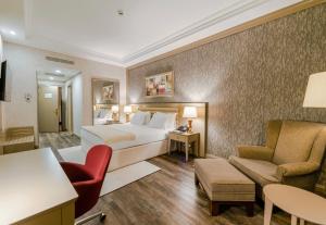 a hotel room with a bed and a couch and a chair at Wellborn Luxury Hotel in Kocaeli
