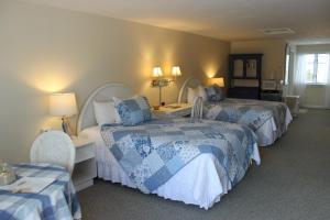 ein Hotelzimmer mit 2 Betten und 2 Stühlen in der Unterkunft Red Horse Inn in Falmouth
