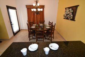 a dining room with a table with plates and chairs at San Felipe Ultra Deluxe Elegance with Spectacular Sea Views in Playa El Paraíso +35 photos