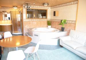 a living room with a tub and a table at HH Huoneistot Suite in Forssa +26 photos