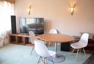 um quarto com uma mesa e cadeiras e uma televisão em HH Huoneistot Suite em Forssa