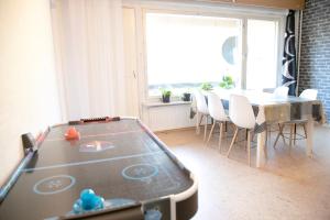mesa de ping pong en una habitación con mesa y sillas en HH Huoneistot Suite en Forssa