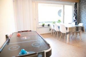 a ping pong table in a room with a table and chairs at HH Huoneistot Suite in Forssa