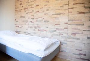 a bedroom with a brick accent wall and a bed at HH Huoneistot Suite in Forssa