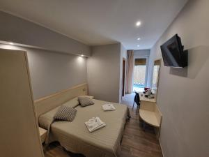 Habitación con 2 camas, escritorio y TV. en Hotel Garni Rosmari, en Brenzone sul Garda
