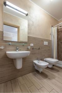 a bathroom with two sinks and a toilet and a mirror at Affittacamere Borgo Roma in Verona
