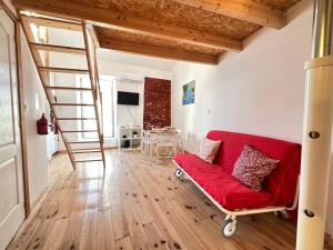 een woonkamer met een rode bank en een ladder bij Lovely Loft in Setúbal