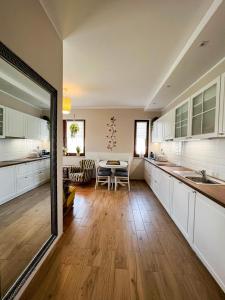 a kitchen with white cabinets and a table in it at Apartament Zdrojowy 62 K in Nałęczów
