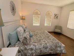 a bedroom with a bed and a chair and windows at 3 bedroom rental condo in La Ventana del Mar San Felipe in San Felipe