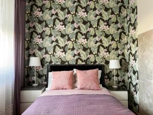 a bedroom with a bed with a floral wallpaper at Apartament Zdrojowy 62 K in Nałęczów