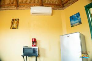 een kamer met een koelkast en een kleine tv bij Getaway from it all - Percebu Beach Studio in Don Pancho