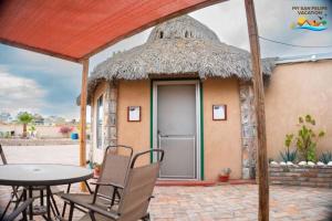 een kleine hut met een tafel en stoelen ervoor bij Getaway from it all - Percebu Beach Studio in Don Pancho +50 foto's