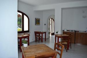 a dining room with tables and chairs and windows at Cocos Park Ischia in Ischia