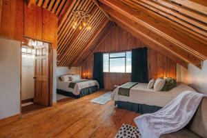 a bedroom with two beds in a room with wooden ceilings at The Red Door Mountain Cabin 