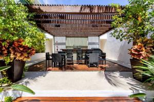 an outdoor patio with tables and chairs and trees at Cozy 1be/1ba on 12 street gym+pool+100mbps internet in Playa del Carmen