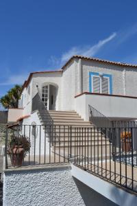 a white house with stairs and a fence at Cocos Park Ischia in Ischia