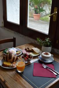 a table with breakfast foods and a cup of orange juice at Cocos Park Ischia in Ischia
