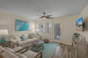 a living room with a couch and a ceiling fan at Jubilee Landing 110 by Vacation Homes Collection in Orange Beach