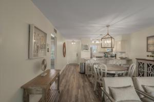 a living room and kitchen with a table and chairs at Jubilee Landing 110 by Vacation Homes Collection in Orange Beach