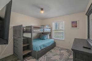 a bedroom with a bunk bed and a desk at Jubilee Landing 110 by Vacation Homes Collection in Orange Beach