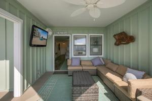 a living room with a couch and a flat screen tv at Jubilee Landing 110 by Vacation Homes Collection in Orange Beach