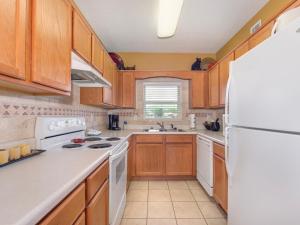 a kitchen with wooden cabinets and a white refrigerator at River View Condo Bear Crossing 302 in Pigeon Forge