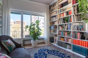 een woonkamer met boekenplanken gevuld met boeken bij Libertà #102 - Guest House Palermo in Palermo