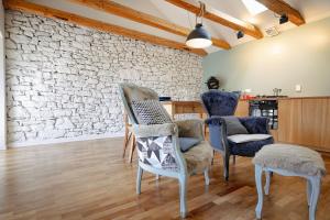 - un salon avec des chaises et un mur en pierre dans l'établissement CASA OPICINA - Elegante appartamento in VILLA CARSICA, à Villa Opicina