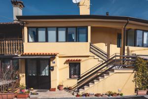 une maison jaune avec un escalier devant elle dans l'établissement CASA OPICINA - Elegante appartamento in VILLA CARSICA, à Villa Opicina