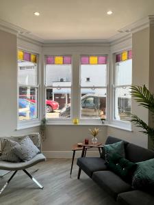 sala de estar con sofá y algunas ventanas en Cliffs Pavilion 2 Bedroom Apartment en Southend-on-Sea