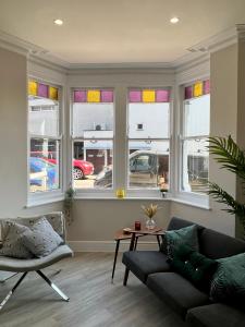 a living room with a couch and some windows at Cliffs Pavilion 2 Bedroom Apartment in Southend-on-Sea