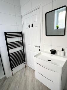 uma casa de banho com um lavatório branco e um espelho. em Cliffs Pavilion 2 Bedroom Apartment em Southend-on-Sea
