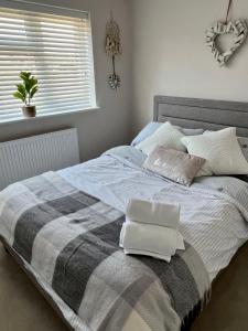 ein Bett mit zwei Kissen darauf in einem Schlafzimmer in der Unterkunft Cliffs Pavilion 2 Bedroom Apartment in Southend-on-Sea