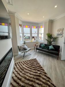 a living room with a couch and a rug at Cliffs Pavilion 2 Bedroom Apartment in Southend-on-Sea