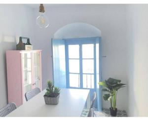贝赫尔-德拉弗龙特拉Casa Arena y Sal en pleno casco antiguo de Vejer的一间设有白色桌子和蓝色门的用餐室 更多18张照片
