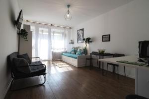 uma sala de estar com um sofá e uma mesa em LénApartman - Marilyn em Pécs
