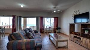 een woonkamer met een bank en een tv bij Condo Vista mar - Beautiful rental condo located in Villas de las Palmas San Felipe in San Felipe