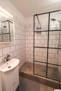 y baño con ducha acristalada y lavamanos. en LénApartman - Marilyn, en Pécs