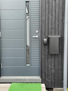 een blauwe deur met een groene mat ervoor bij Orres Guesthouse Stenhamra, Ekerö in Stenhamra