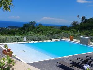 a swimming pool with a view of the ocean at PYRAMID JOY, 2 Bedroom Villa, Ocho Rios, Jamaica in Ocho Rios