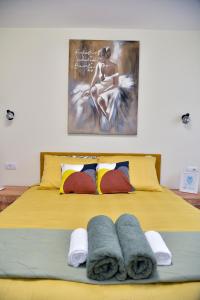 a yellow bed with towels on top of it at Apartman Lenka in Arandjelovac