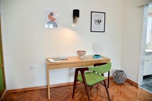 a desk in a room with a green chair at Apartman Lenka in Arandjelovac