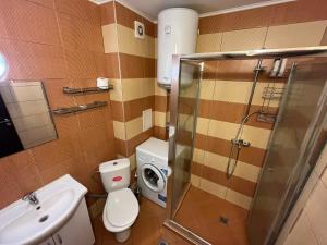 a bathroom with a toilet and a sink and a shower at Vqra Sarafovo in Burgas