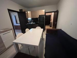 a kitchen with a white table and chairs in a room at Vqra Sarafovo in Burgas +6 photos