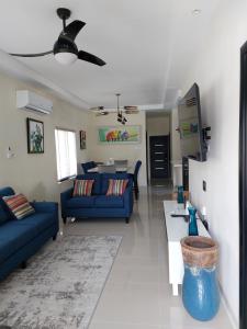una sala de estar con 2 sofás azules y una mesa. en PYRAMID JOY, 2 Bedroom Villa, Ocho Rios, Jamaica, en Ocho Ríos