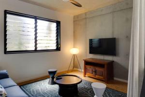 uma sala de estar com um sofá e uma televisão de ecrã plano em Escape 2 the City NEW apartment 3bed Highgate Hill em Brisbane