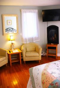 a bedroom with a couch and a chair and a television at Red Horse Inn in Falmouth