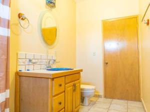 a bathroom with a sink and a toilet and a mirror at 2BR /2BA Family Vacation Home with WiFi in Playa Hawaii
