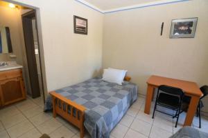 a room with a bed and a table and a desk at San Felipe Rental Studio #1 Free WiFi and Cable TV in San Felipe