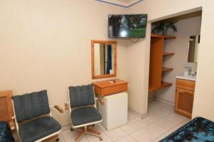una camera con due sedie e una TV a parete di San Felipe Rental Studio 3 Free WiFi and Cable TV a San Felipe